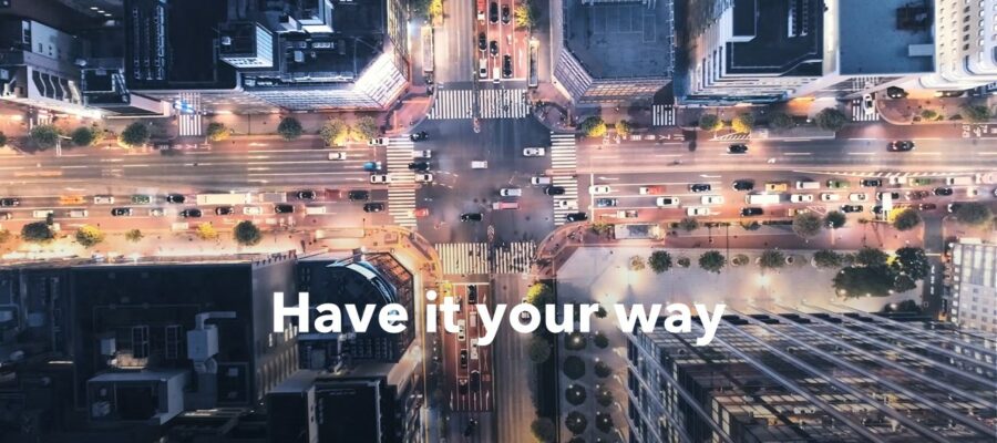 Häuserschlucht in einer Großstadt, Aufnahme einer Kreuzung von oben, und darin ein Text "Have it your way".