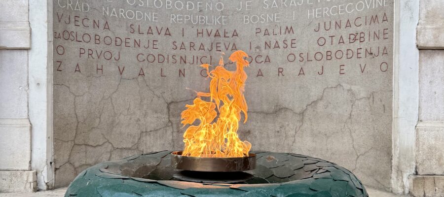 Ewiges Feuer Genozid Srebrenica Eine ewige Flamme in der Mitte eines Gedenkkranzes aus Stein, im Hintergrund eine Inschrift